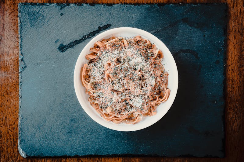 Pizza sauce being spread on dough